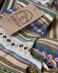 Fancy Folk woven garment detail with embroidered floral stripes and HHGC hang tag